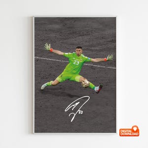 Puede incluir: Impresión digital enmarcada de un portero con uniforme verde, lanzándose para detener un balón de fútbol. La imagen incluye la firma del jugador y el número 23. El fondo es una superficie oscura y texturizada.