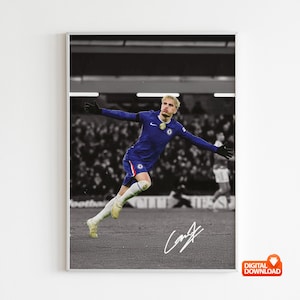 Könnte beinhalten: Gerahmter Digitaldruck eines Fußballspielers in blauem Trikot, der mit ausgestreckten Armen jubelt. Das Bild ist in Graustufen gehalten, der Spieler in Farbe. Die Unterschrift des Spielers befindet sich unten.