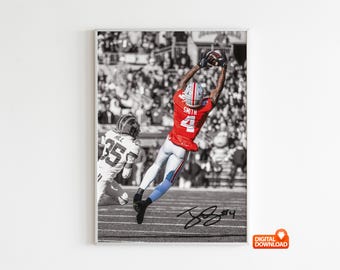 May include: A framed black and white photograph of a football player in mid-air, catching a football. The player wears a red jersey with the number 4 and the name "Smith". The image is signed and includes the text "DIGITAL DOWNLOAD".