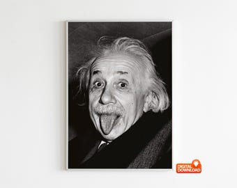 May include: Black and white framed print of Albert Einstein sticking out his tongue. The portrait shows Einstein with his eyes wide and his tongue extended, a playful and iconic image.