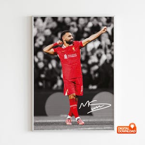 May include: Framed print of a footballer in a red kit, celebrating with arms raised. The background is a monochrome crowd. The player's signature is present. The image is labelled "DIGITAL DOWNLOAD".