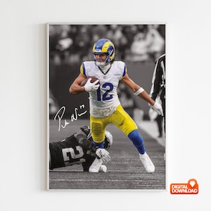 Puede incluir: Impresión digital enmarcada que presenta a un jugador de fútbol americano con el uniforme de los Rams, número 12, corriendo con el balón. La imagen es en color, con un fondo en blanco y negro. La firma del jugador es visible. La impresión está etiquetada como "DESCARGA DIGITAL".