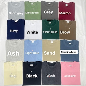 May include: A collection of various colored t-shirts, including sport grey, navy, white, ash, light blue, sand, begi, black, wash, and light pink. Each shirt is neatly folded and labeled with its color name. The shirts are displayed on a white surface.