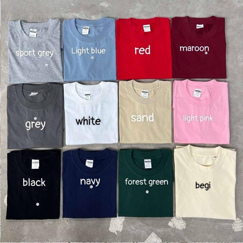 Peut inclure: Une collection de douze t-shirts &agrave; col rond de diff&eacute;rentes couleurs : gris sport, bleu clair, rouge, bordeaux, gris, blanc, sable, rose clair, noir, marine, vert for&ecirc;t et begi. Chaque t-shirt porte son nom de couleur.