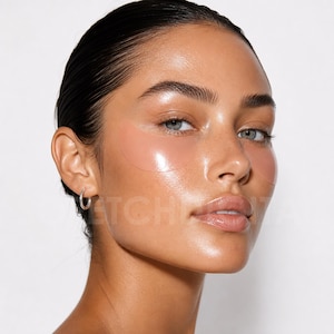 May include: A pair of smooth, semi-transparent, peach-colored under-eye patches applied to the skin beneath the eyes. The patches have a glossy, gel-like texture and follow the natural contour of the cheekbones, resting below the lower lash line.