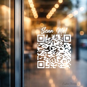 Peut inclure: Autocollant de code QR blanc sur une porte vitrée avec le texte "Scan Me!". L'autocollant est au centre de la vitre, avec un arrière-plan flou d'un intérieur de bâtiment. Les mots "Custom Stickers Co" sont en bas.