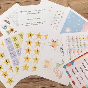 Peut inclure: Ensemble de feuilles imprimées pour un système de récompenses pour enfants, avec des autocollants en forme d'étoiles, des illustrations de licornes et de dinosaures, et un guide utilisateur multilingue. Le texte "Positive Reward System for Children" est présent.