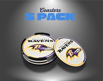 May include: A set of Baltimore Ravens coasters. The coasters are white with the team logo in purple, black, and gold. The text "Baltimore Ravens" is printed on the coasters. The image also includes the text "Coasters 5 PACK".
