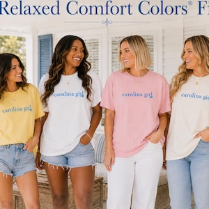 Pu&ograve; includere: Quattro magliette a maniche corte con girocollo nei colori giallo, bianco, rosa e crema. Ogni maglietta presenta la scritta "carolina girl" stampata in blu sul petto. Le magliette hanno una vestibilit&agrave; rilassata e sono disposte in fila.
