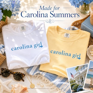 Pu&ograve; includere: Due magliette a girocollo, una bianca e una giallo pallido, ciascuna con la scritta blu "carolina girl" e una piccola icona a forma di sagoma di uno stato. Le magliette sono esposte insieme a una borsa di paglia e due piccole foto.