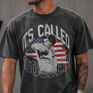 Gray soccer fan t-shirt with bold “It’s Called Soccer” print, American sports theme, streetwear