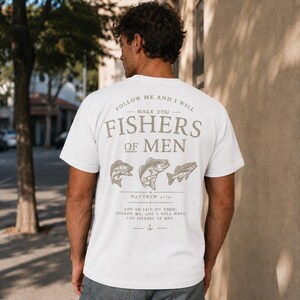White Christian fishing shirt mockup showing large Fishers of Men scripture design on back with detailed fish artwork and Matthew 4:19 verse on male model.