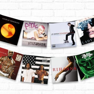 May include: A collection of eight album covers hanging on a white brick wall. The albums are by Coldplay, Pink, Justin Timberlake, Lady Gaga, 50 Cent, G-Unit, Rihanna, and The Black Eyed Peas.