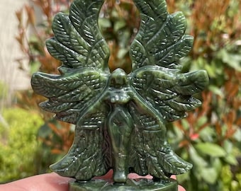 May include: Green jade stone carving of a winged angel with detailed feathers. The angel is standing with arms outstretched and has a serene expression.