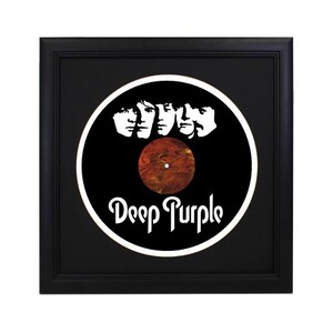 May include: A black framed record display with a white silhouette of four musicians' faces and the text "Deep Purple". The record is a red and orange swirl.