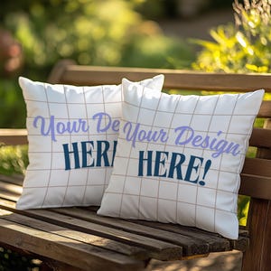 Könnte beinhalten: Zwei weiße Kissen mit einem Gittermuster und dem Text "Your Design Here!" in lila und blauer Schrift.