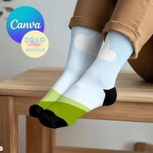 Puede incluir: Calcetines altos con fondo azul claro y diseños de corazón y círculo blancos. Los calcetines tienen una franja verde y blanca en el tobillo y punteras negras. Los logotipos de Canva y Drag & Drop Mockup son visibles.