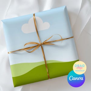 以下が含まれることがあります： 青い空、白い雲、緑の丘が描かれた風景デザインのギフト。 金色のリボンで結ばれています。 CanvaとDrag Drop Mockupのロゴが表示されています。