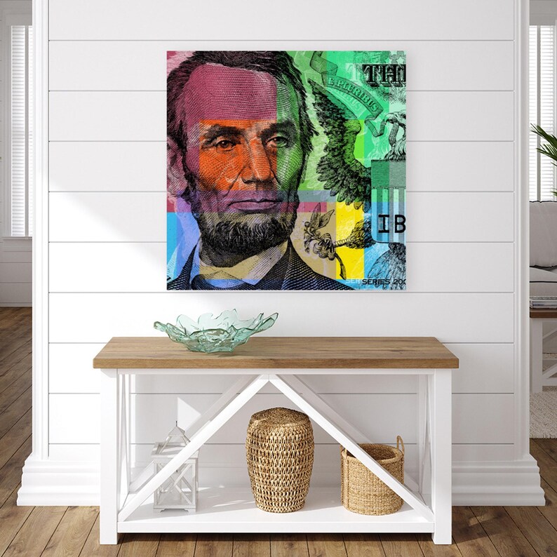 May include: A colorful abstract art print featuring a close-up of Abraham Lincoln's face from a US dollar bill. The image is divided into squares of different colors, including red, green, blue, yellow, and orange. The text "ONE THOUSAND" and "SERIES 2009" are visible in the image.
