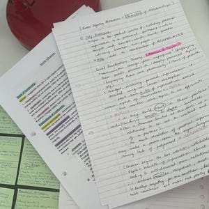 May include: A stack of handwritten notes on white paper, with text and diagrams. The notes cover topics like social influence, conformity, and factors affecting attraction. Some text is highlighted in pink. A red object is visible in the background.