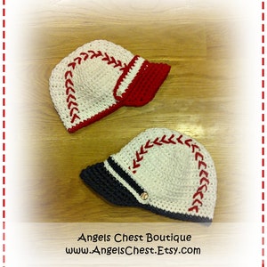 May include: Two crocheted baseball caps with white yarn and red and black brims. The caps have white stitching that resembles baseball stitching. The text "Angels Chest Boutique www.AngelsChest.Etsy.com" is at the bottom of the image.