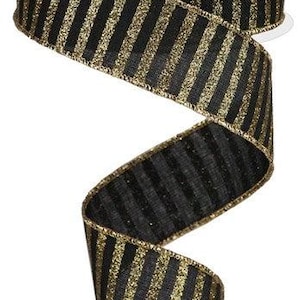 May include: A roll of black and gold striped ribbon. The ribbon has a glittery gold stripe design on a black background. The ribbon is on a white spool.