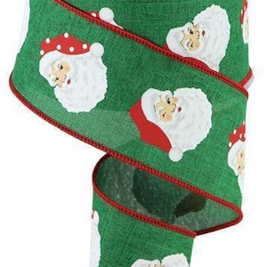 May include: Green and red ribbon with a white Santa Claus face pattern. The ribbon has a red edge and is made of a textured fabric.