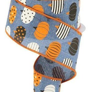 May include: A 2.5 inch wide blue ribbon with an orange edge. The ribbon features a repeating pattern of orange, black, and white pumpkins on a blue background.