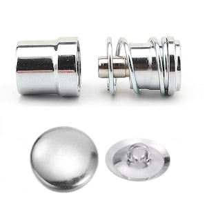May include: Shiny silver metal snap fasteners and a spring-loaded mechanism. The image shows two sets of snap fasteners, one with a spring and the other without. The fasteners are designed for use in clothing or other fabric-based projects.