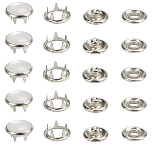 Op de afbeelding: Een verzameling zilverkleurige drukkers, inclusief kap, socket, stud en oogje componenten. De doppen hebben een witte, platte oppervlakte en drie pinnen. De studs en sockets zijn cirkelvormig met een centraal verhoogd gebied. Ideaal voor naai- en knutselprojecten.