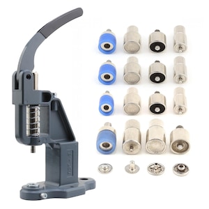 May include: A gray snap press machine with a black handle and a set of silver and blue attachments. Several silver snaps are also included. This tool is designed for attaching snaps to fabric or other materials.