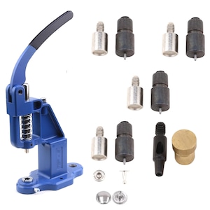 Peut inclure: Une presse manuelle bleue avec une poignée noire, un ressort et divers accessoires métalliques. Comprend des composants argentés et noirs, ainsi que des boutons-pression argentés et un cylindre en laiton. Idéal pour le bricolage.