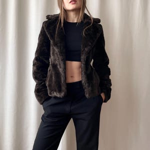 Peut inclure: Ensemble de trois tasses en céramique avec une finition mate et mouchetée. Les tasses sont de couleur crème, gris clair et gris foncé. Chaque tasse a un design simple et minimaliste.