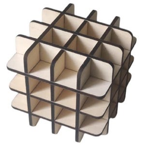 May include: A cube-shaped wooden structure with a grid pattern. The light-coloured wood has dark brown edges, creating a contrast. The open design suggests a decorative or organizational purpose. The structure is likely for display.