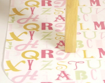 Laminated Cotton Oilcloth Splat Mat  Art cloth kids tablecloth high chair alphabet in pinks and gold SELECT YOUR SIZE