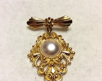 Gold metal bar pin with pearl drop dangle.