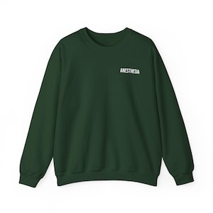 Könnte beinhalten: Ein dunkelgrüner Pullover mit dem Wort "ANESTHEIA" in weiß auf der Vorderseite.