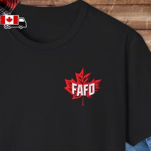 Puede incluir: Camiseta negra con un diseño de hoja de arce roja y el texto "FAFO" en blanco.
