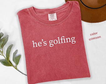 Comfort Colors® He's Golfing Shirt, Golfing Season Shirt, Golfer Wife Shirt, Golfing Mom Shirt, Golf Player Shirt for Mom, Golf Lover, t944