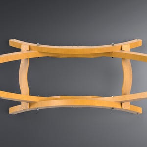 May include: A wooden hammock stand with a curved, oval design. The stand is made of light-colored wood and features curved supports and connecting pieces. Metal hardware is visible at the ends of the oval frame. The stand is designed to hold a hammock.