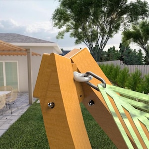 May include: A wooden hammock frame with a light green hammock. The frame is made of light brown wood and has a metal hook for the hammock. The background shows a house, patio, and green lawn.