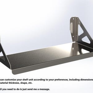 Op de afbeelding: Een zwart metalen rek met een zilveren metalen plank. Het rek is aan de muur bevestigd met twee beugels. Het rek is ontworpen om te worden aangepast met verschillende afmetingen, materialen en vormen.