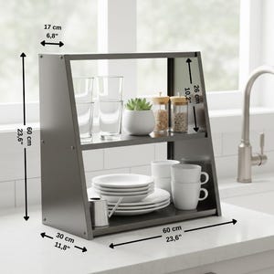 Op de afbeelding: Een donkergrijs keukenschap, 60 cm hoog, 60 cm breed en 30 cm diep, met twee planken. Het bevat glazen, een kleine plant, kruidenpotjes, borden, kopjes en een kleine kan. Het schap is 17 cm diep.