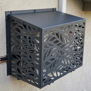 Puede incluir: Una taza de cerámica blanca con un asa negra y el texto "But First, Coffee" en negrita negra. La taza se encuentra sobre un fondo borroso, sugiriendo un ambiente acogedor.