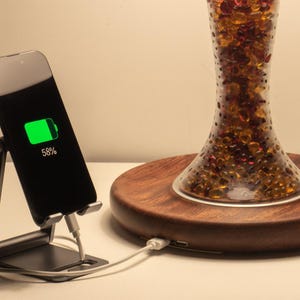 Handmade bone china table lamp with dual USB ports charging a smartphone beside the solid Huali wood base.