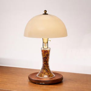 Handmade bone china table lamp with a translucent shade, solid Huali wood base, brass fittings, and dual USB ports on a wooden tabletop.