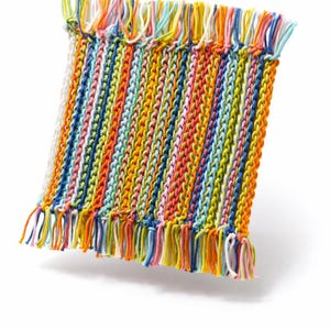 May include: A colorful, rectangular woven textile with vertical stripes in shades of yellow, orange, blue, green, and pink. The edges are finished with fringe. The textile is likely a decorative item, such as a small rug or wall hanging.