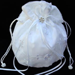 May include: A white drawstring bag with a delicate, sheer overlay. The bag is adorned with a sparkling, silver-toned embellishment at the center and features white drawstrings with pearl-like accents. The bag is likely for a wedding or special occasion.