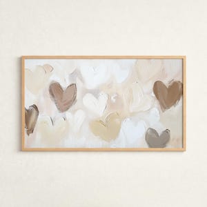 Könnte beinhalten: Gerahmtes abstraktes Gemälde mit mehreren Herzformen in Weiß, Beige und Braun. Die Herzen sind mit sichtbaren Pinselstrichen auf hellem Hintergrund gemalt, wodurch ein texturierter Effekt entsteht. Der Rahmen besteht aus hellem Holz.