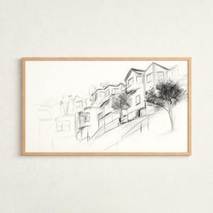 Könnte beinhalten: Eine gerahmte Schwarz-Weiß-Skizze eines Viertels am Hang. Das Kunstwerk zeigt eine Reihe von Häusern mit unterschiedlichen architektonischen Stilen, Bäumen und einer abschüssigen Straße. Die Skizze befindet sich in einem hellen Holzrahmen.